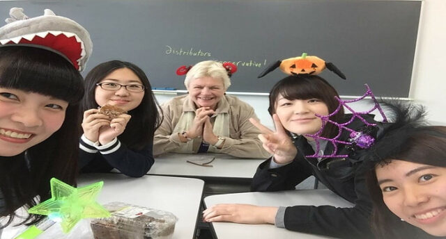 Linden with her students celebrating Halloween in the classroom.
